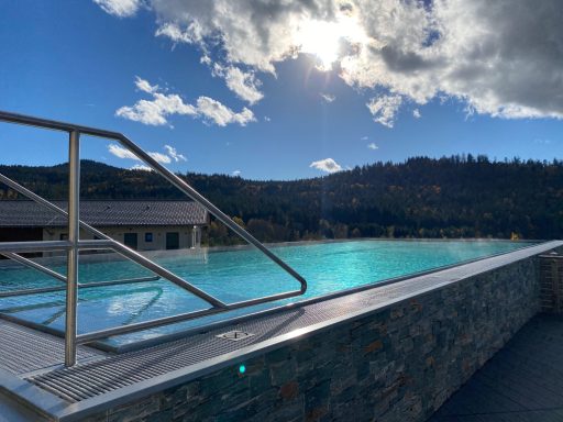 Moderne Schwimmhalle mit Aussicht auf Berge und strahlendem Himmel.